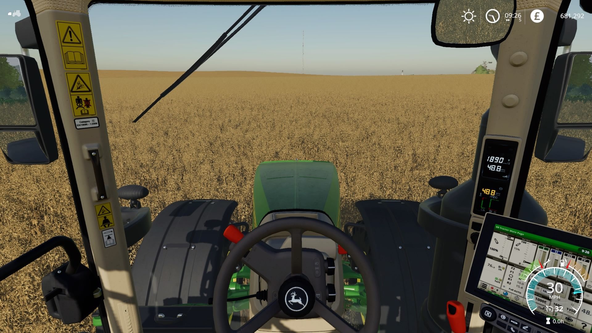 Cockpit view of driving through a field in Farming Simulator