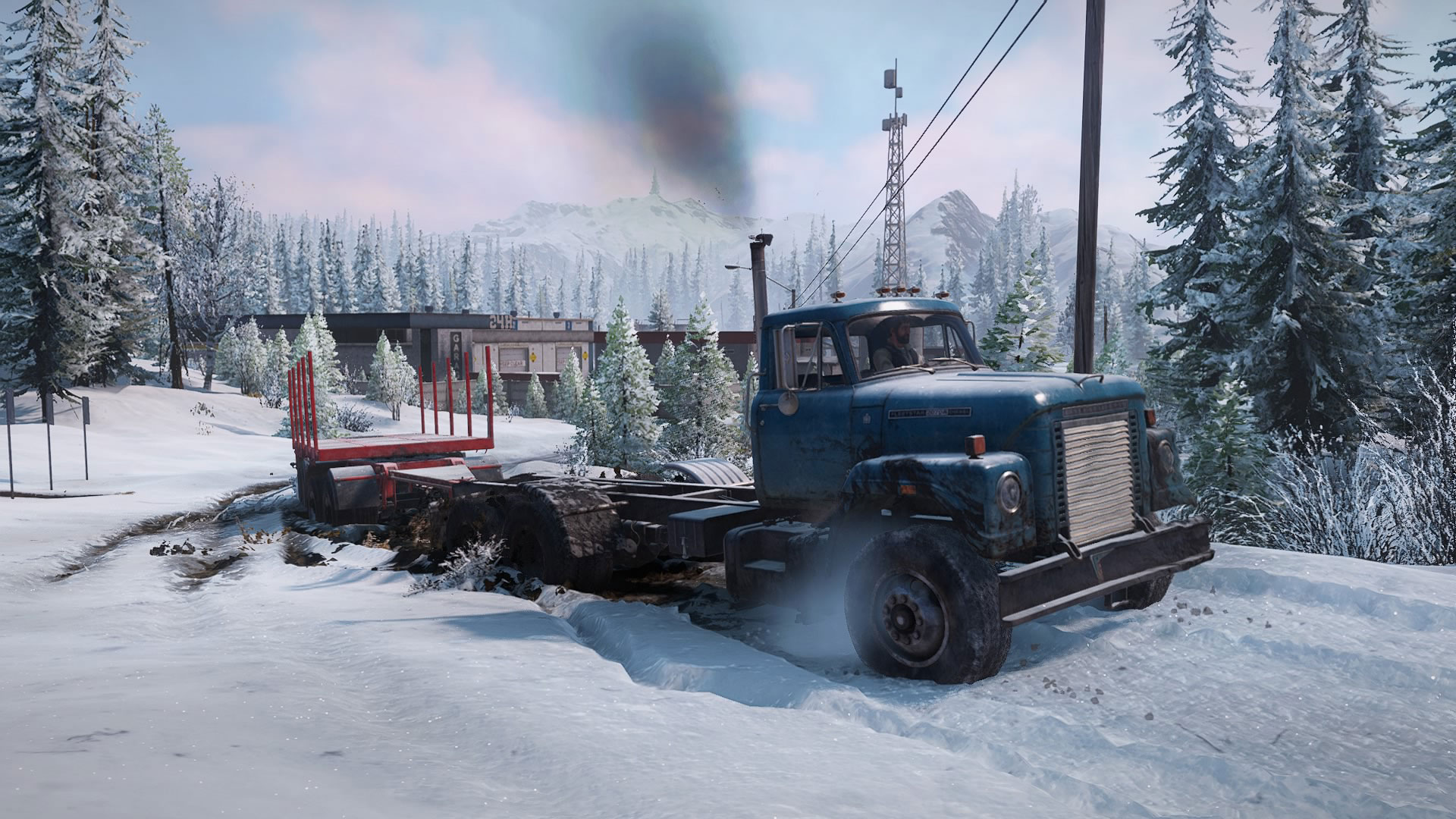 A flatbed truck driving through a snowy path
